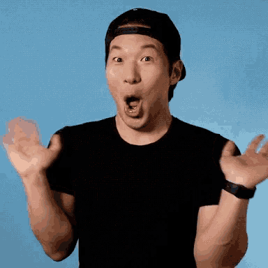 a man wearing a baseball cap and a black shirt is making a surprised face with his mouth open .