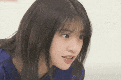 a close up of a woman 's face with a blue shirt