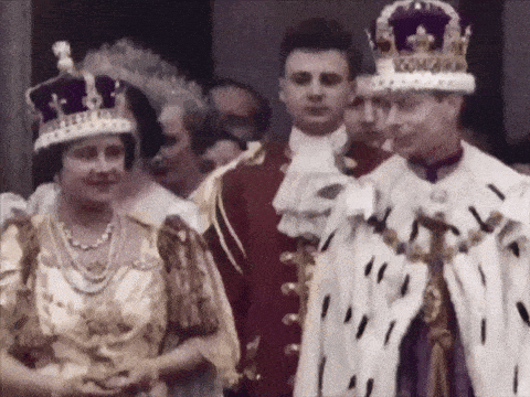 a man in a crown with the word king on it stands next to a woman