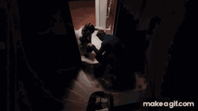 a man and a woman are kneeling in front of a door with make a gif.com in the corner