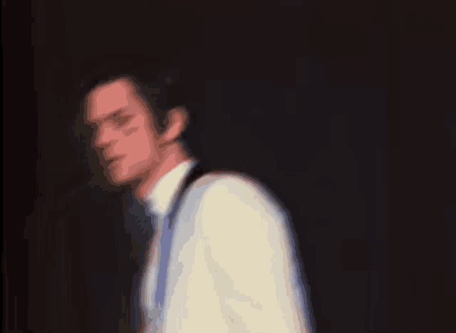 a blurry picture of a man in a suit and tie playing a guitar on a stage .