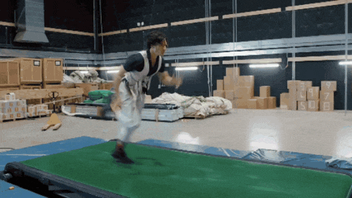 a man is running on a treadmill in a warehouse with boxes in the background