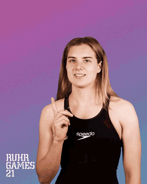 a woman is wearing a speedo tank top and pointing up