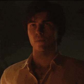 a man in a white shirt has a cross on his neck