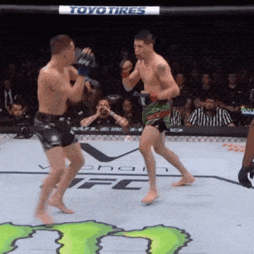 two men are fighting in a boxing ring with a toyo tires sign behind them
