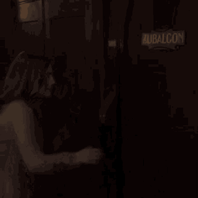 a woman is standing in front of a door that says balcony