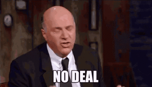 a bald man in a suit and tie is making a funny face and saying no deal .