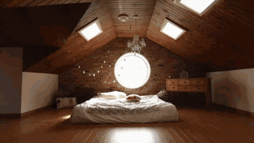 an attic bedroom with a bed and a window