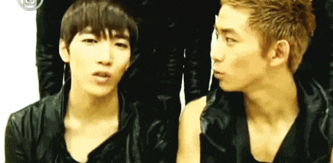 two young men are standing next to each other and making funny faces .