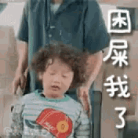 a little boy is sitting in a chair next to a man .