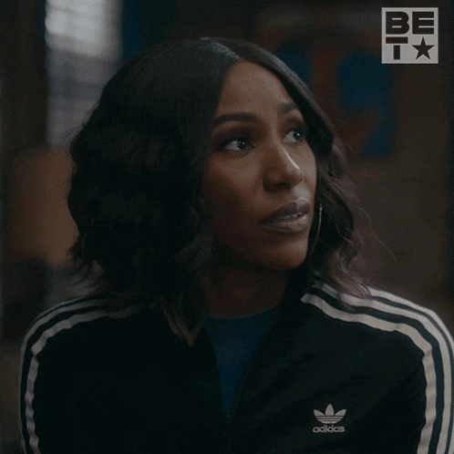 a woman wearing an adidas jacket says nope in front of her face