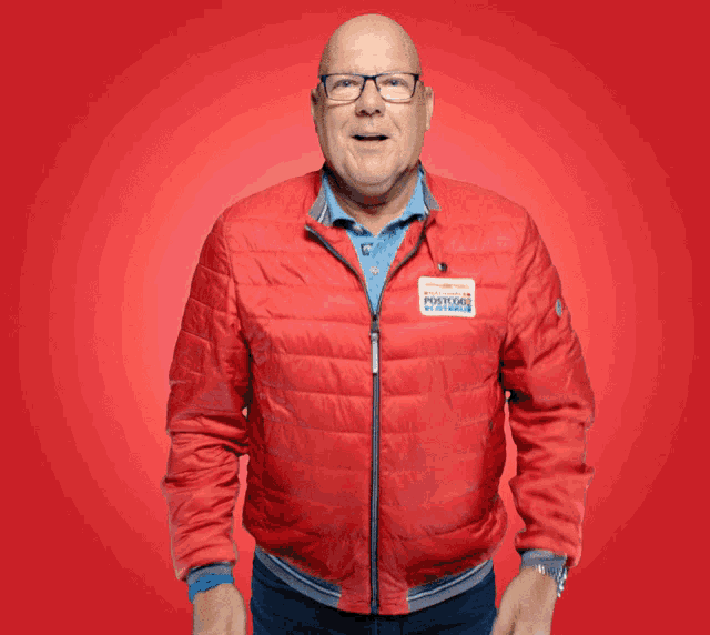 a man wearing a red jacket that says ' porsche ' on the back