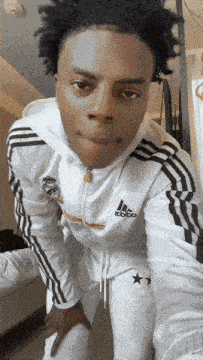 a young man wearing a white adidas hoodie