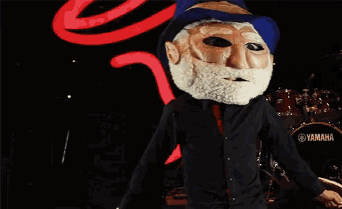 a man in a mask stands in front of a drum that says yamaha