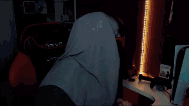 a woman wearing glasses and a hijab is sitting in front of a computer