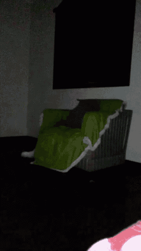 a white cat is standing next to a green chair