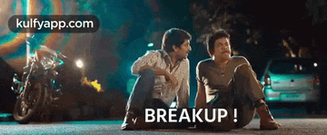 two men are sitting on the ground in front of a motorcycle and the word breakup is written on the ground