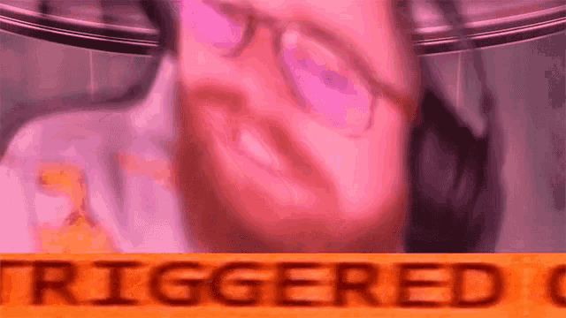 a close up of a person 's face with the word triggered written in orange