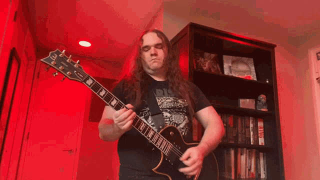 a man with long hair is playing a guitar with the letter e on it