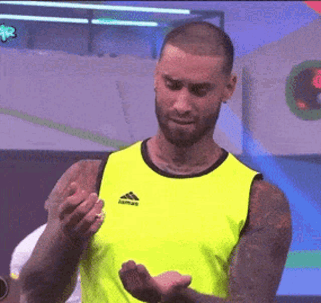 a man in a neon yellow adidas tank top