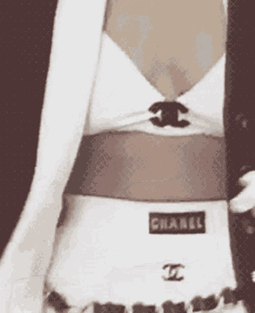 a woman is wearing a white chanel top and shorts