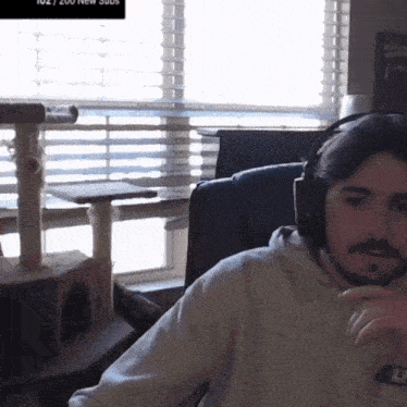 a man wearing headphones is sitting in front of a window