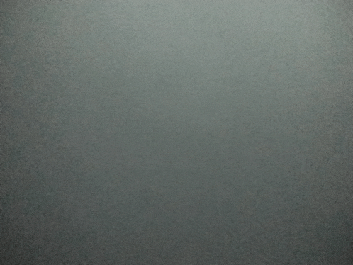 a close up of a gray background with a few small dots on it