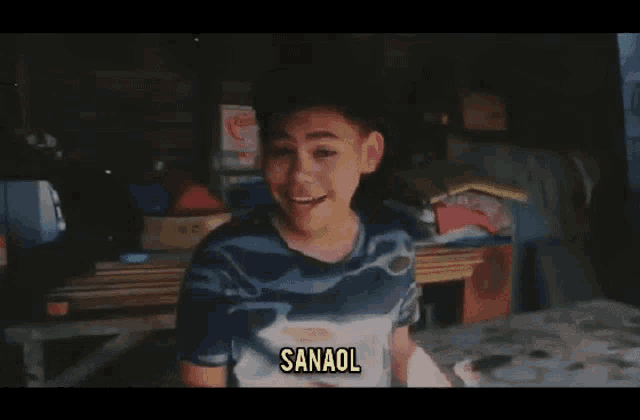 a young boy wearing a blue shirt with sanaol written on it