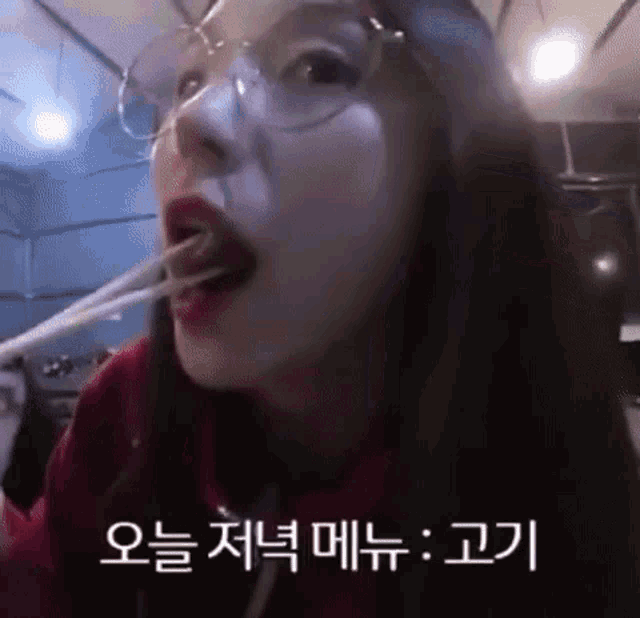 a woman wearing glasses and a red sweater is eating noodles with chopsticks .