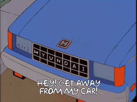 a shadow of a man is cast on a blue hyundai