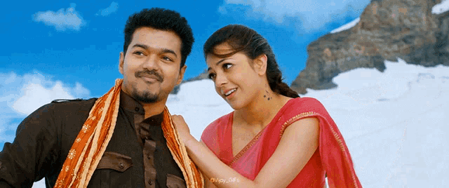 a man and a woman are standing next to each other and the woman is wearing a pink sari