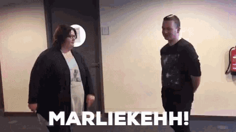 a man and a woman are standing next to each other in a hallway and the man is saying marliekehh .