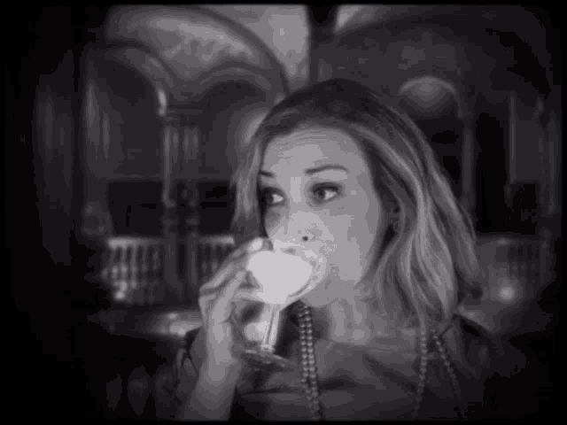 a woman is drinking from a martini glass