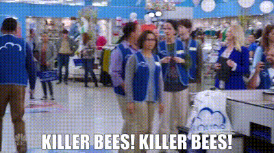 a group of store workers are standing in a store talking to customers .