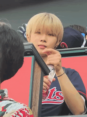 a man wearing a shirt that says ts is holding a bottle of water