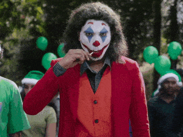 a man dressed as a clown eating a lollipop