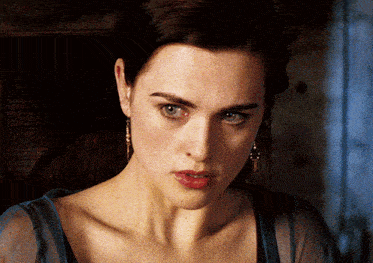 a close up of a woman 's face with earrings on