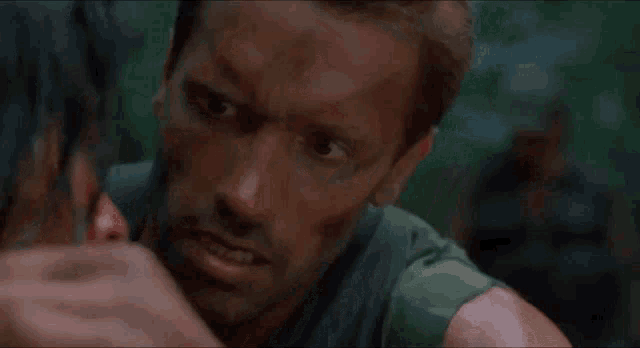 a man in a green shirt is looking at another man in a green shirt .