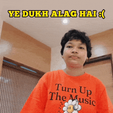 a person wearing an orange t-shirt that says turn up the music