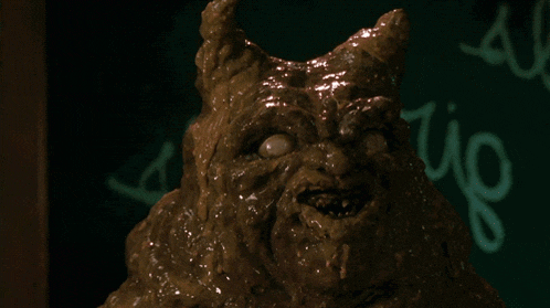a statue of a monster with the word rio written on a blackboard