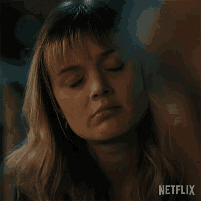 a close up of a woman 's face with netflix written on the bottom right