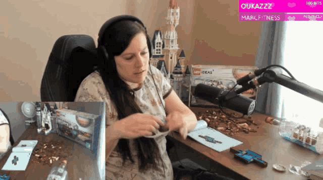 a woman wearing headphones sits at a desk in front of a microphone with the words oukazzz on the bottom
