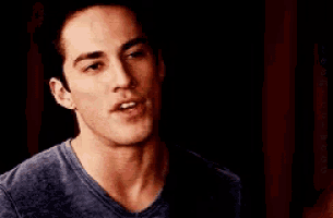 a close up of a man 's face in a blue shirt
