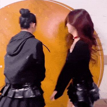 two women are standing next to each other in front of a wooden table .