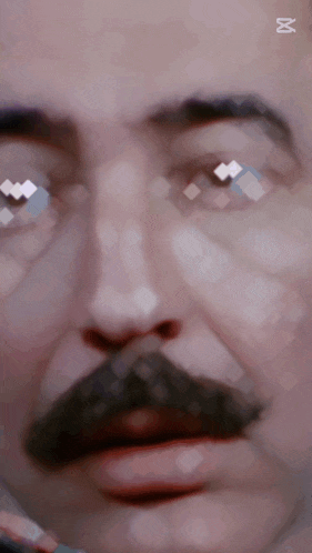 a close up of a man 's face with the letter m on the bottom left