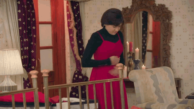 a woman in a red dress is standing in a room