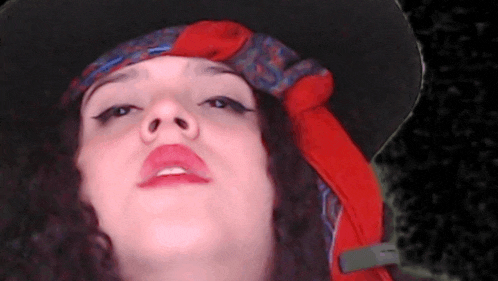 a close up of a woman wearing a hat and scarf .