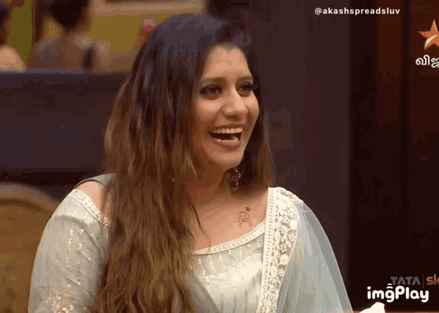 a woman is laughing in front of a star channel