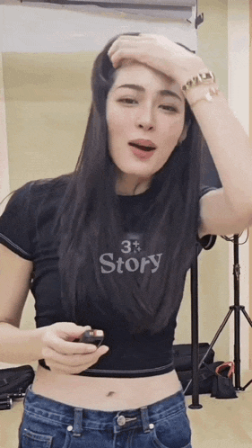 a woman wearing a black crop top that says story