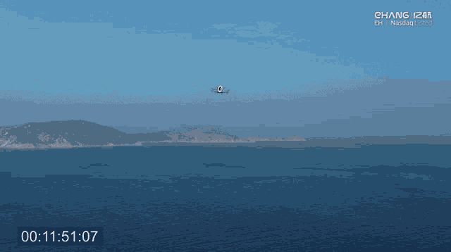 a video of a plane flying over a body of water shows the time as 11 51 10